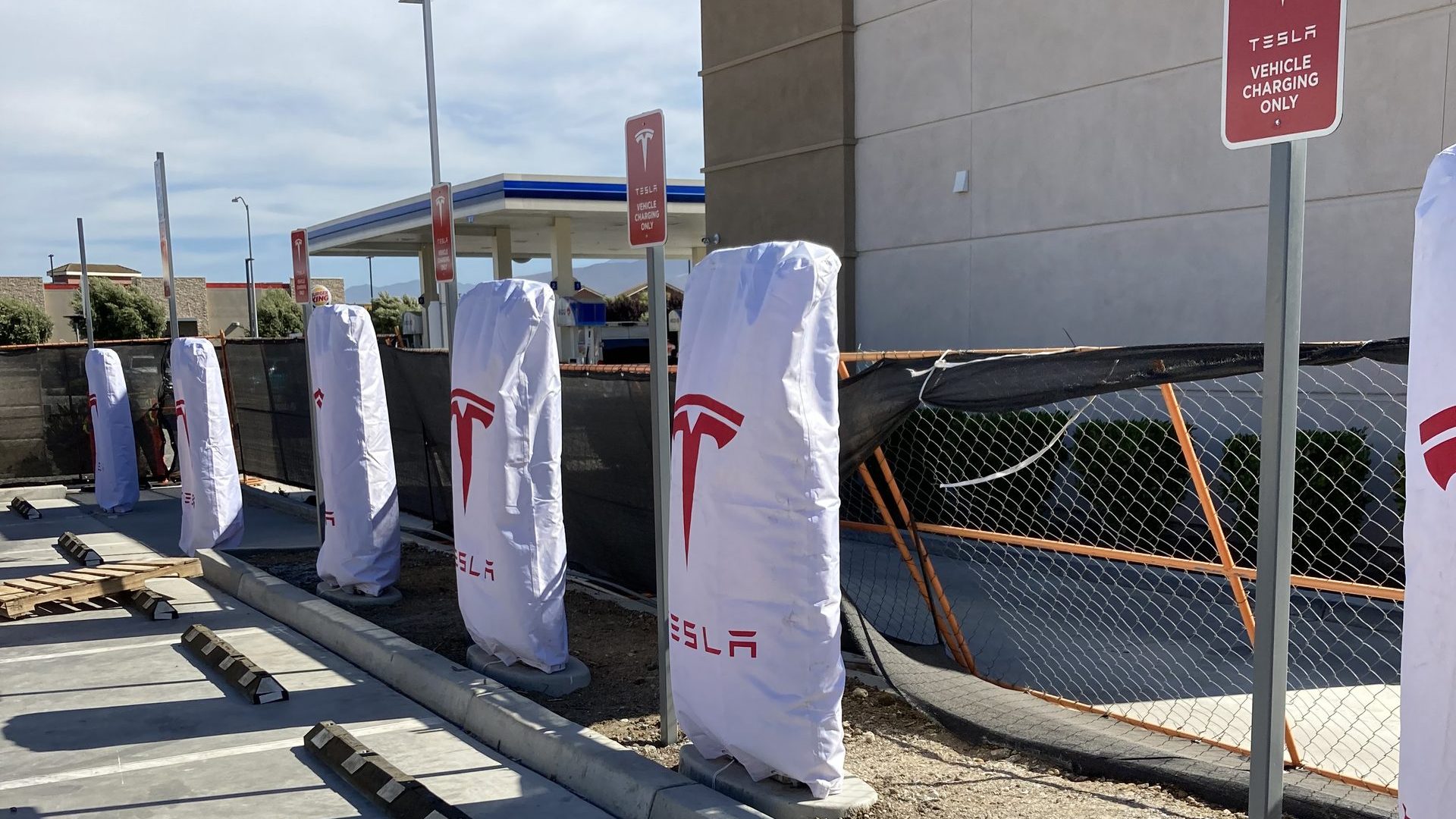 Row of covered DC fast charging stations installed at a retail site