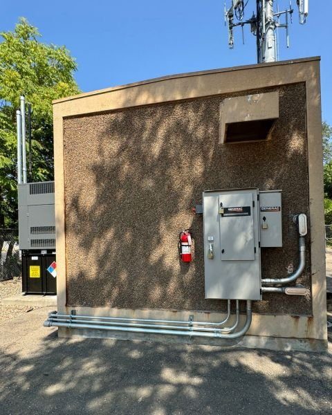 Equipment shelter with generator, exterior panels, and conduit runs installed by JMES
