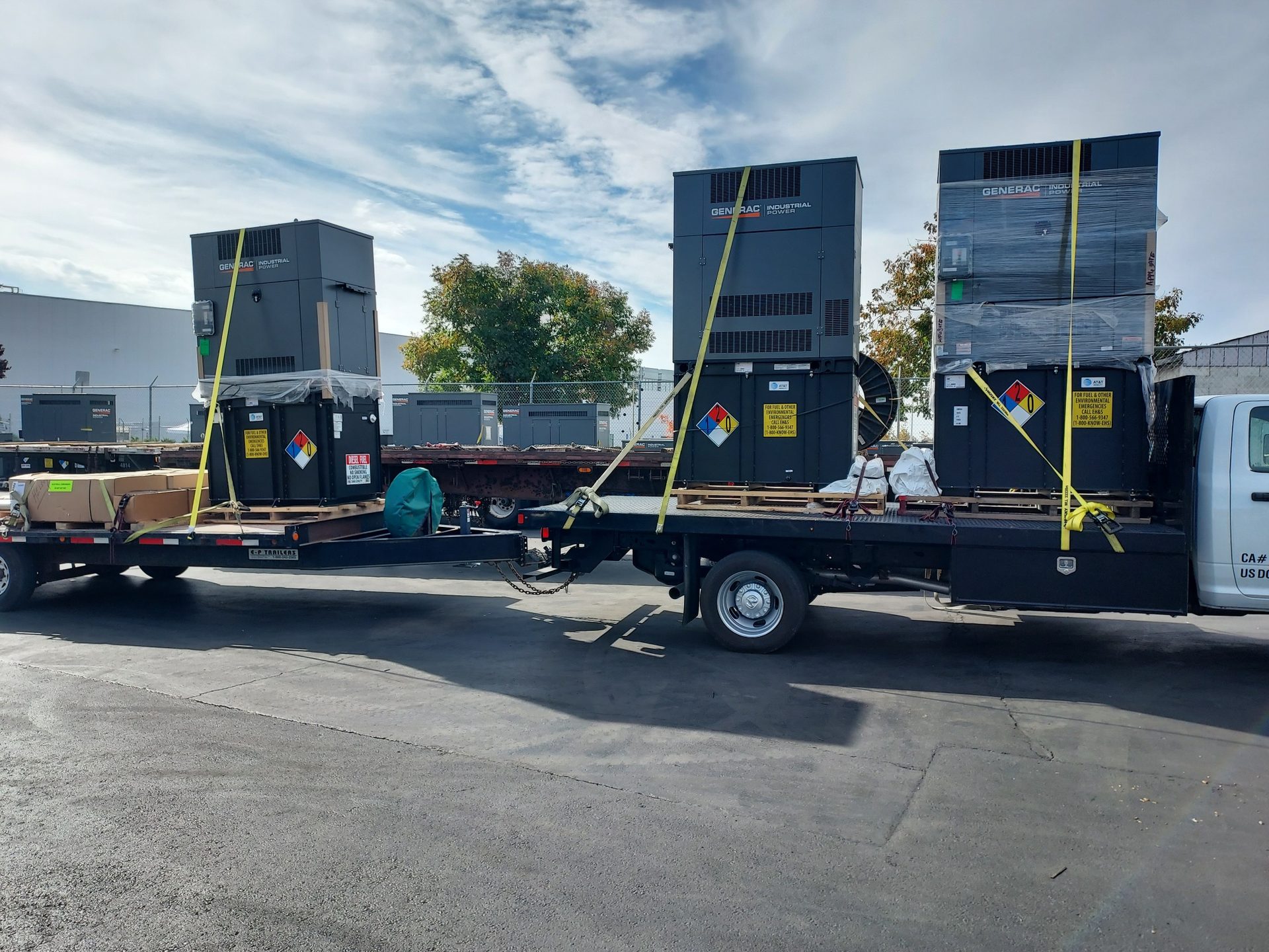 Multiple backup generators strapped to a flatbed truck for site delivery