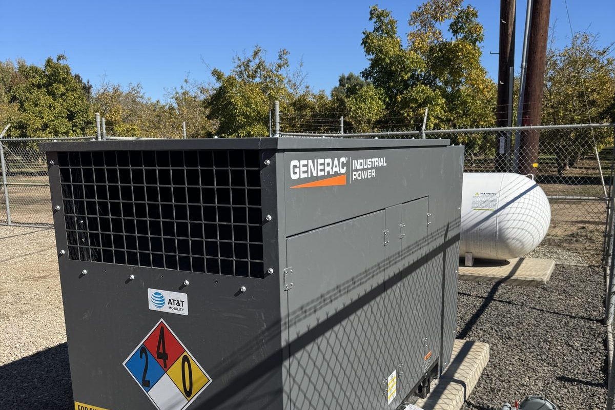 Generac industrial gas generator with LP tank at a fenced remote site